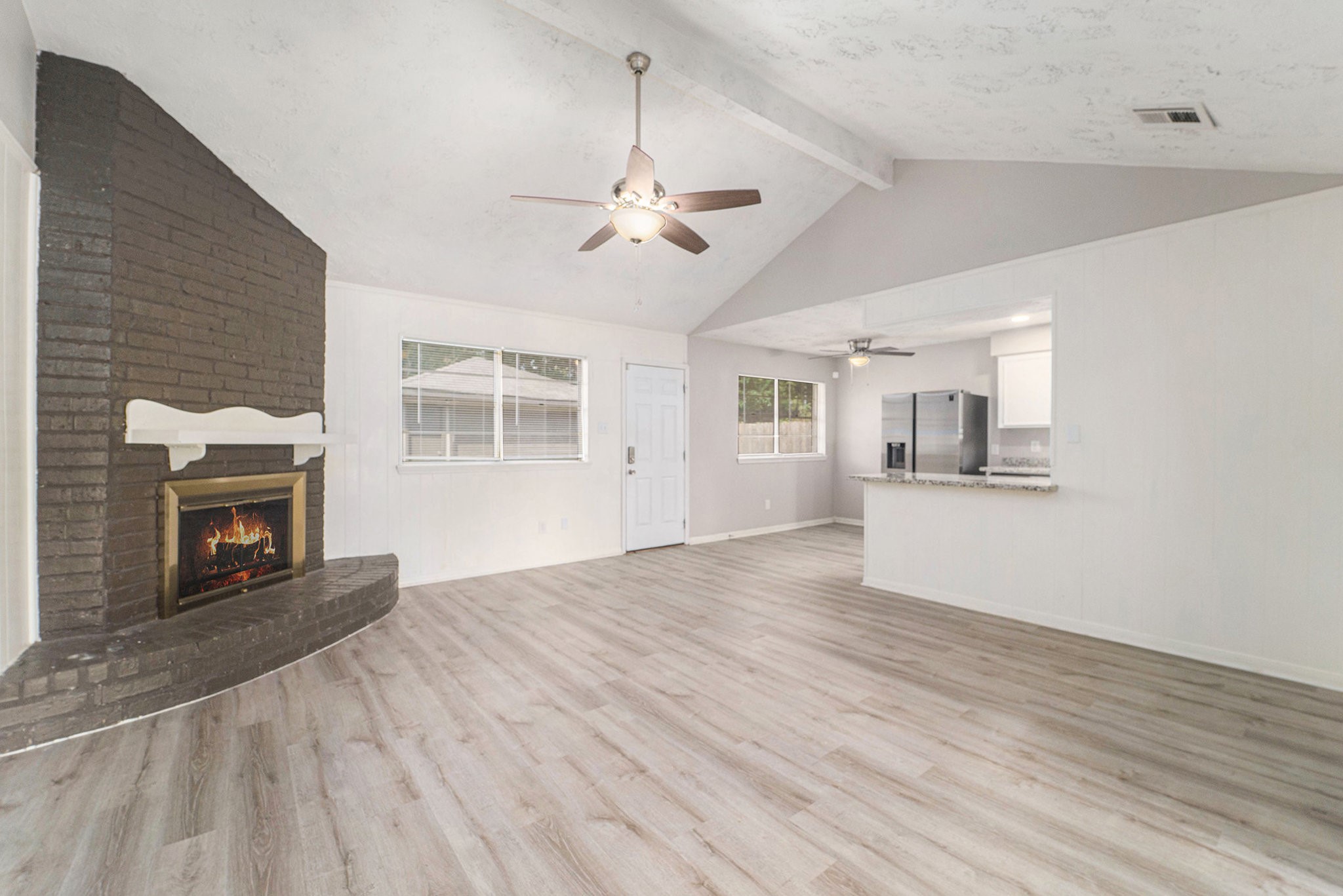 23235 Earlmist Drive Spring, TX 77373 - Photo 6 of 33 a view of a livingroom with wooden floor a fireplace and windows
