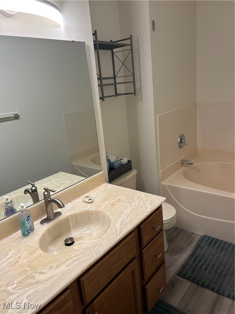 6695 Clingan Road, Unit 24 Youngstown, OH 44514 - Photo 14 of 26 Bathroom featuring a bath, vanity, and wood finished floors