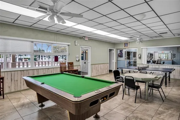 a room with pool table and windows