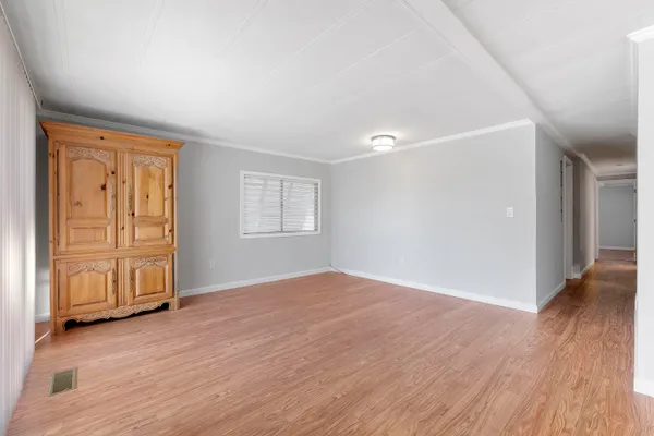 an empty room with wooden floor and closet