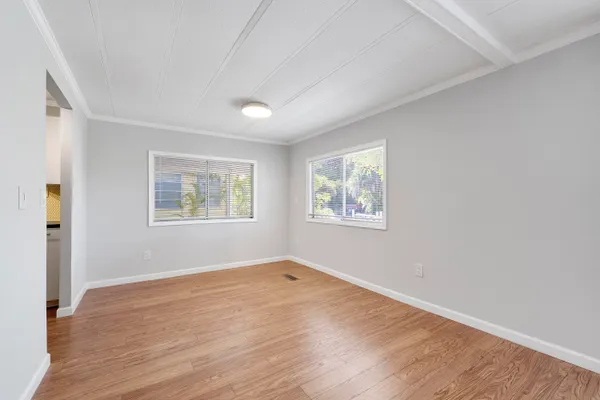 a view of empty room with wooden floor