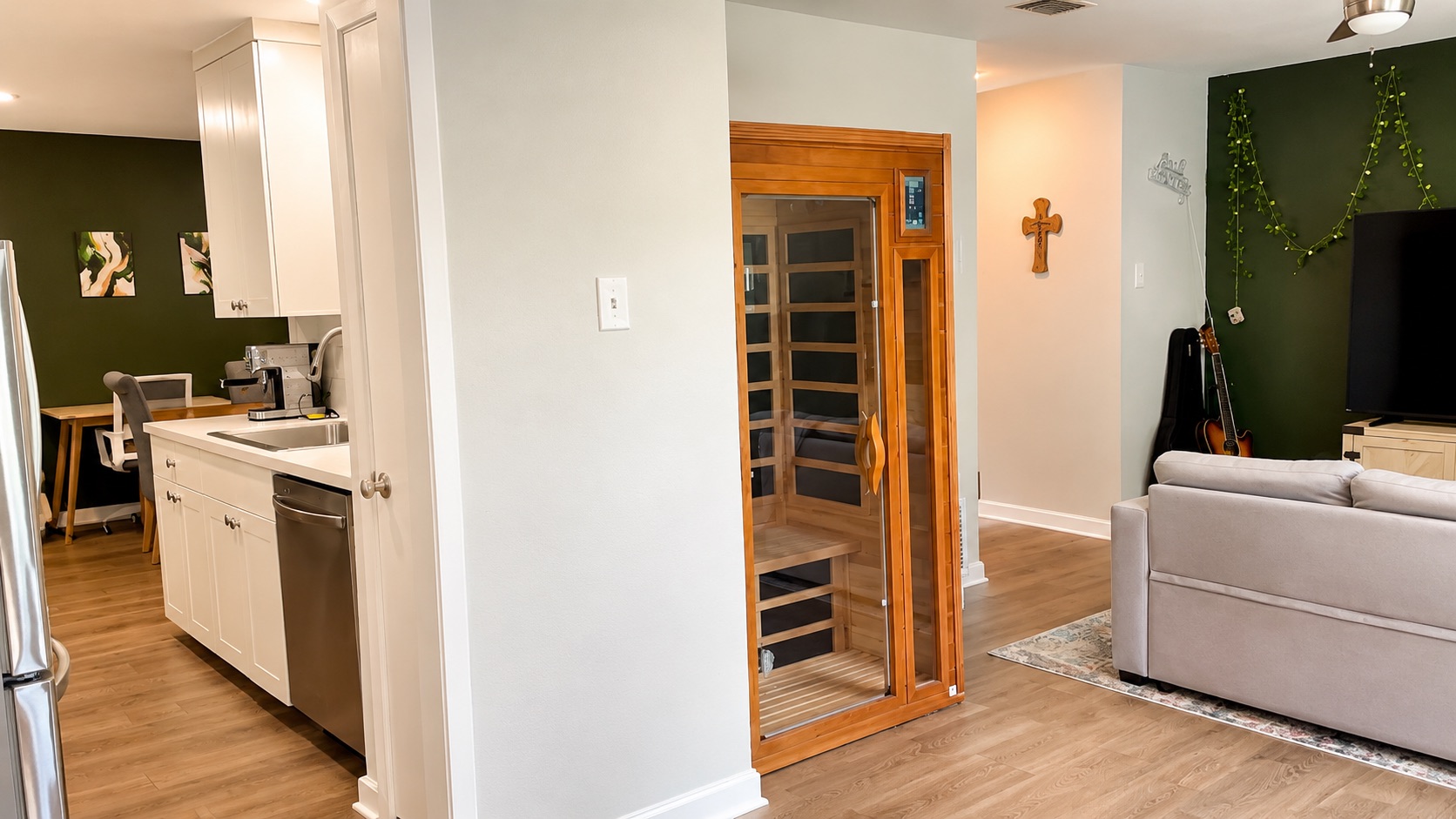 6016 Signal Point Austin, TX 78724 - Photo 4 of 20 A compact kitchen with sleek white cabinetry transitions seamlessly into a living area with warm wood flooring.
