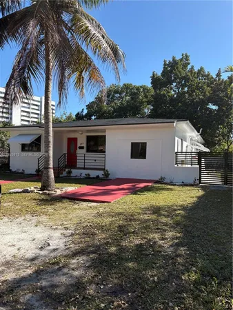 a view of a house with a yard and palm tree