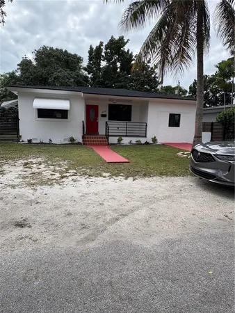 a view of a house with backyard and a car parked in it