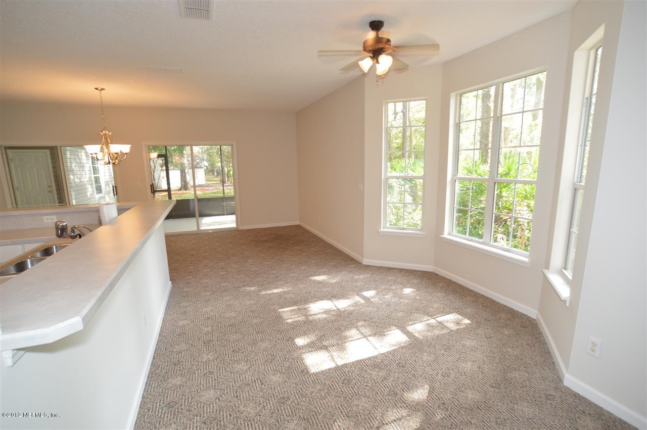 4665 Raggedy Point Road Fleming Island, FL 32003 - Photo 65 of 85 a view of a big room with windows and chandelier fan