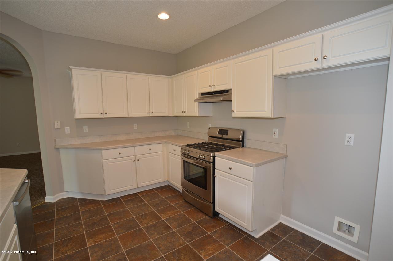 4665 Raggedy Point Road Fleming Island, FL 32003 - Photo 68 of 85 a kitchen with a stove a sink and a refrigerator