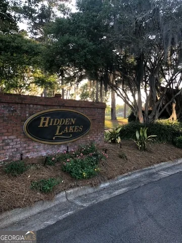 a sign board with a house in the background