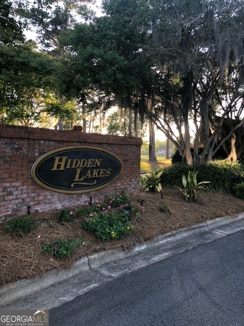 a sign board with a house in the background