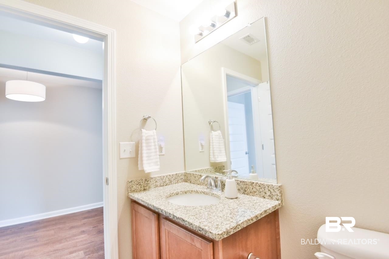 17430 Harding Drive Foley, AL 36535 - Photo 27 of 37 Half bath featuring vanity, toilet, visible vents, and wood finished floors