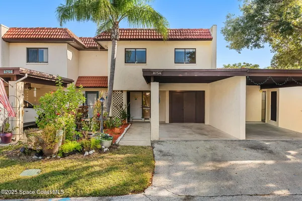 a view of a house with a yard and potted plants