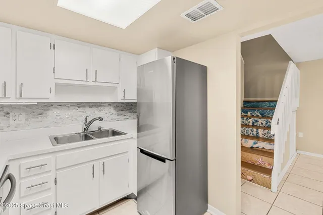 a kitchen with stainless steel appliances white cabinets and a refrigerator