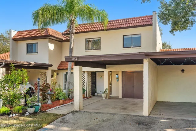 a view of a house with a yard and potted plants