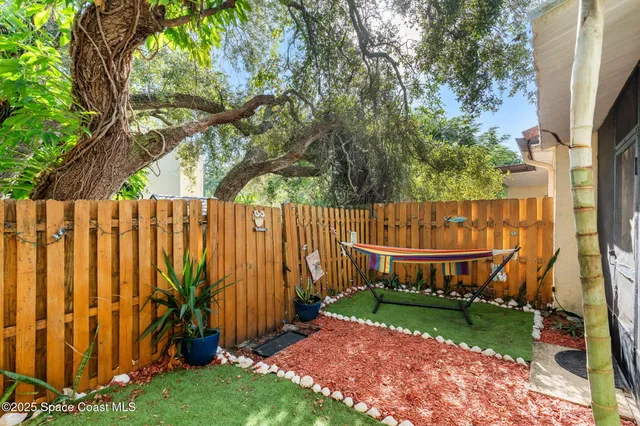 a view of yard with small cabin and wooden fence