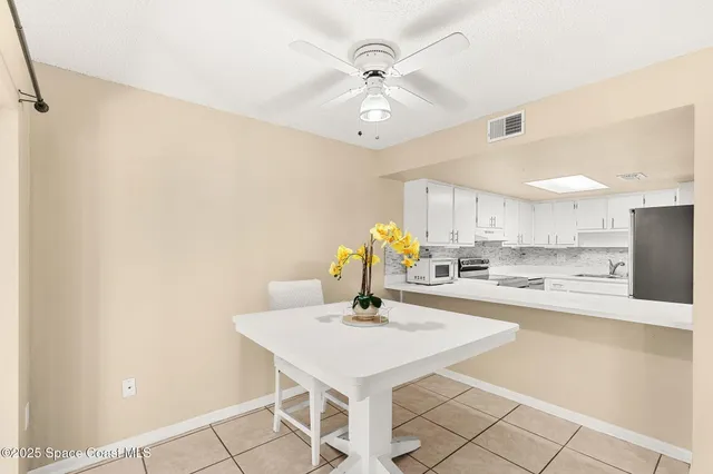 a kitchen with a sink a refrigerator and white cabinets