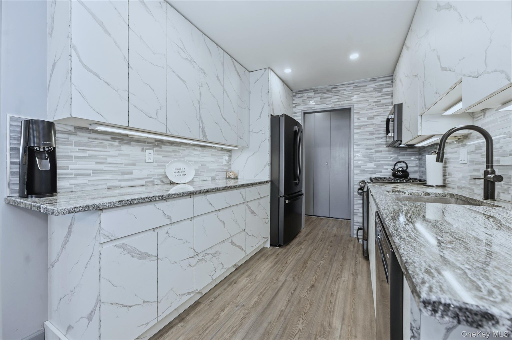 522 Shore Road, Unit 2AA Long Beach, NY 11561 - Photo 12 of 32 a kitchen with stainless steel appliances granite countertop a sink a stove and a refrigerator