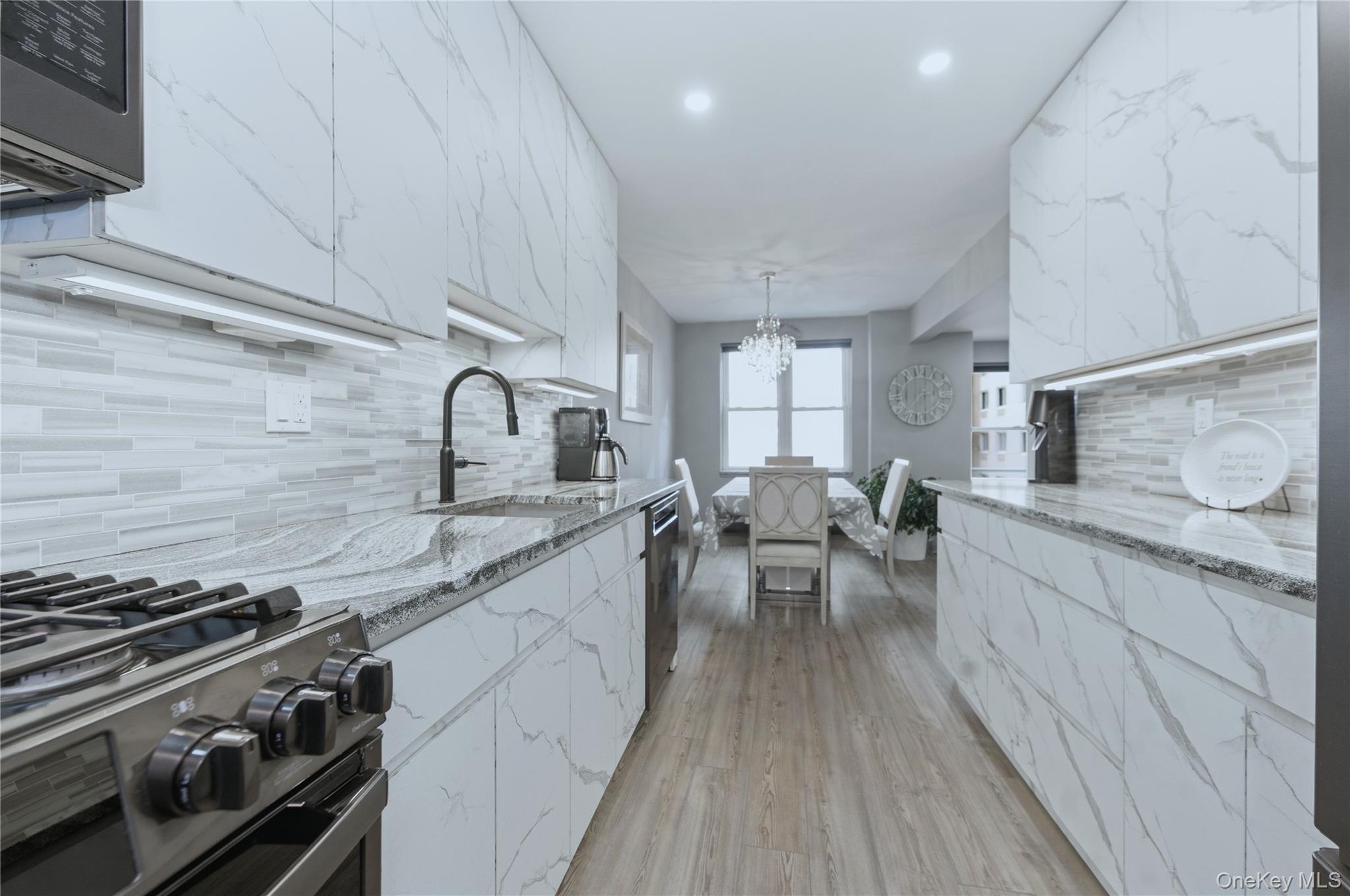 522 Shore Road, Unit 2AA Long Beach, NY 11561 - Photo 13 of 32 a kitchen with sink stove and cabinets