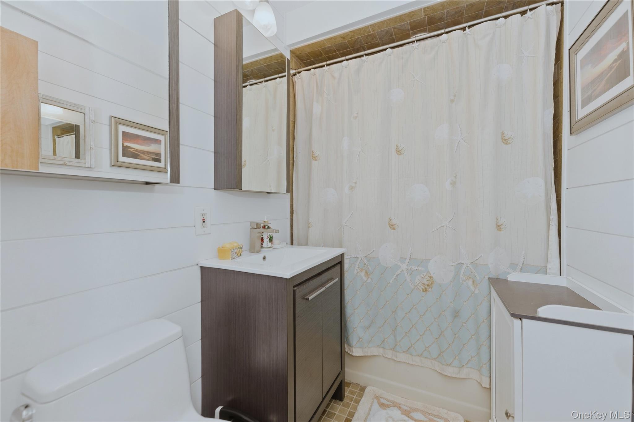 522 Shore Road, Unit 2AA Long Beach, NY 11561 - Photo 17 of 32 a bathroom with a sink a toilet and a mirror