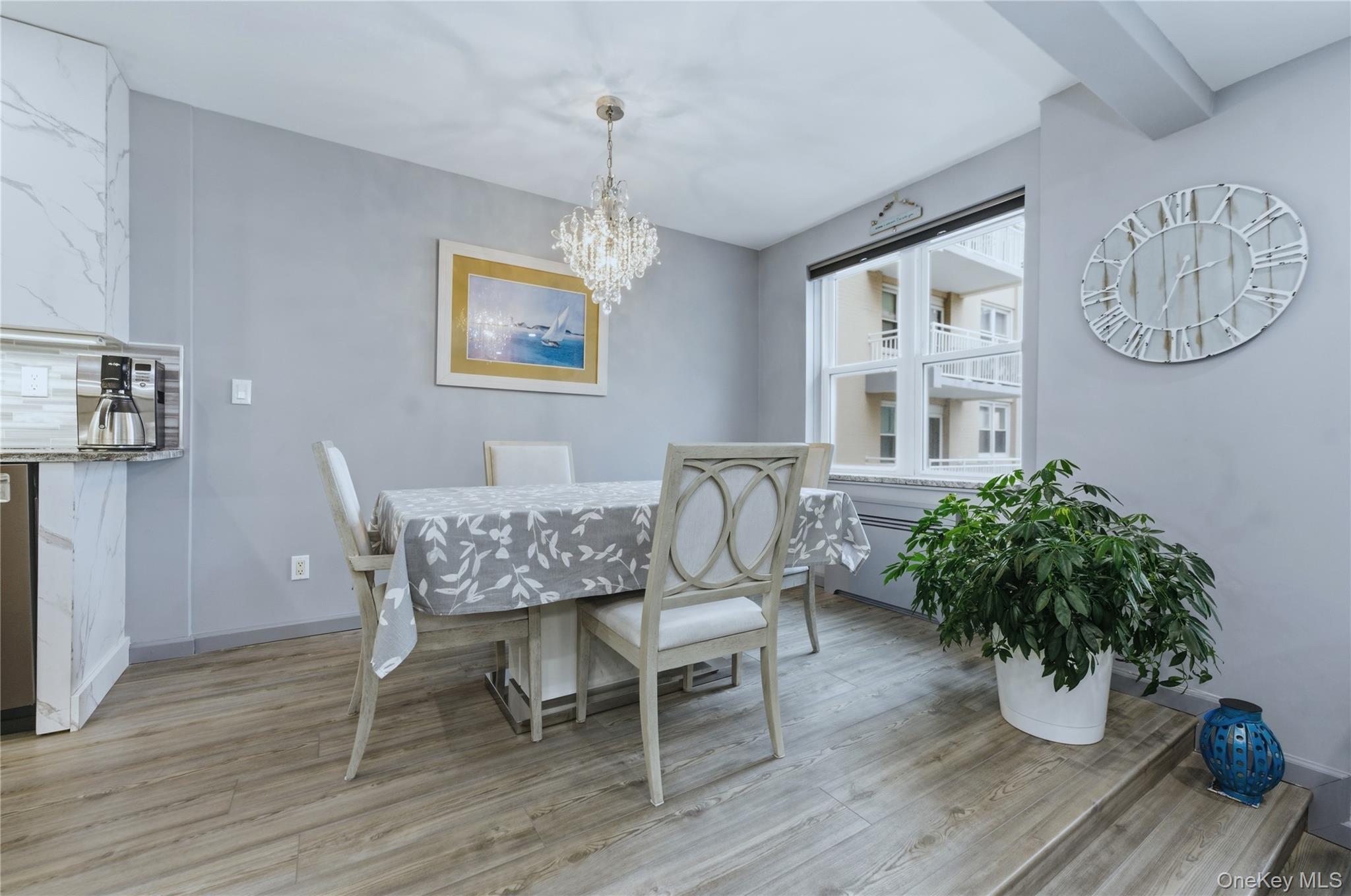 522 Shore Road, Unit 2AA Long Beach, NY 11561 - Photo 10 of 32 a dining room with furniture a chandelier and wooden floor