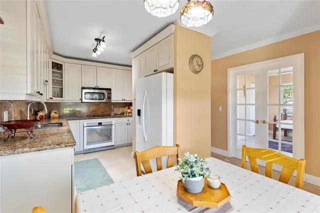 a kitchen with stainless steel appliances granite countertop a sink a stove and a refrigerator