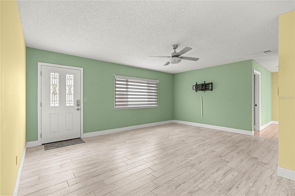 8470 Southwest 107th Place Ocala, FL 34481 - Photo 2 of 44 a view of an empty room with window and wooden floor