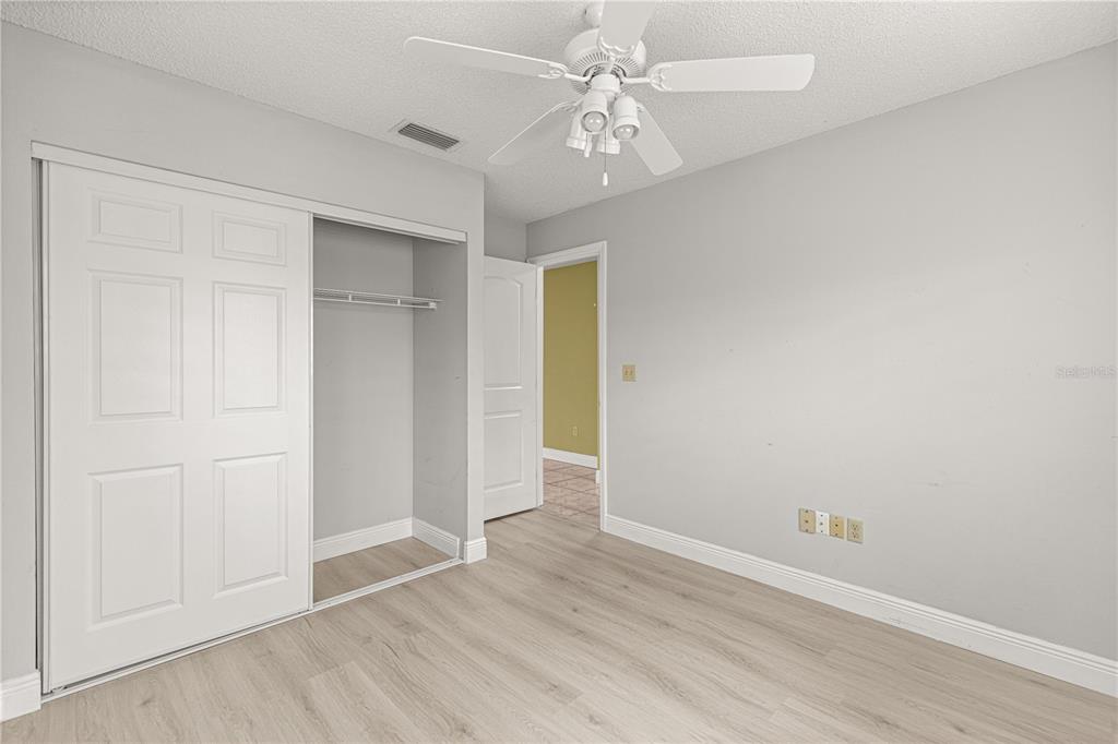 8470 Southwest 107th Place Ocala, FL 34481 - Photo 28 of 44 an empty room with wooden floor and ceiling fan