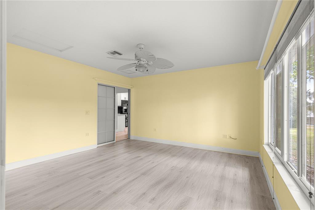 8470 Southwest 107th Place Ocala, FL 34481 - Photo 3 of 44 a view of an empty room with wooden floor and a window