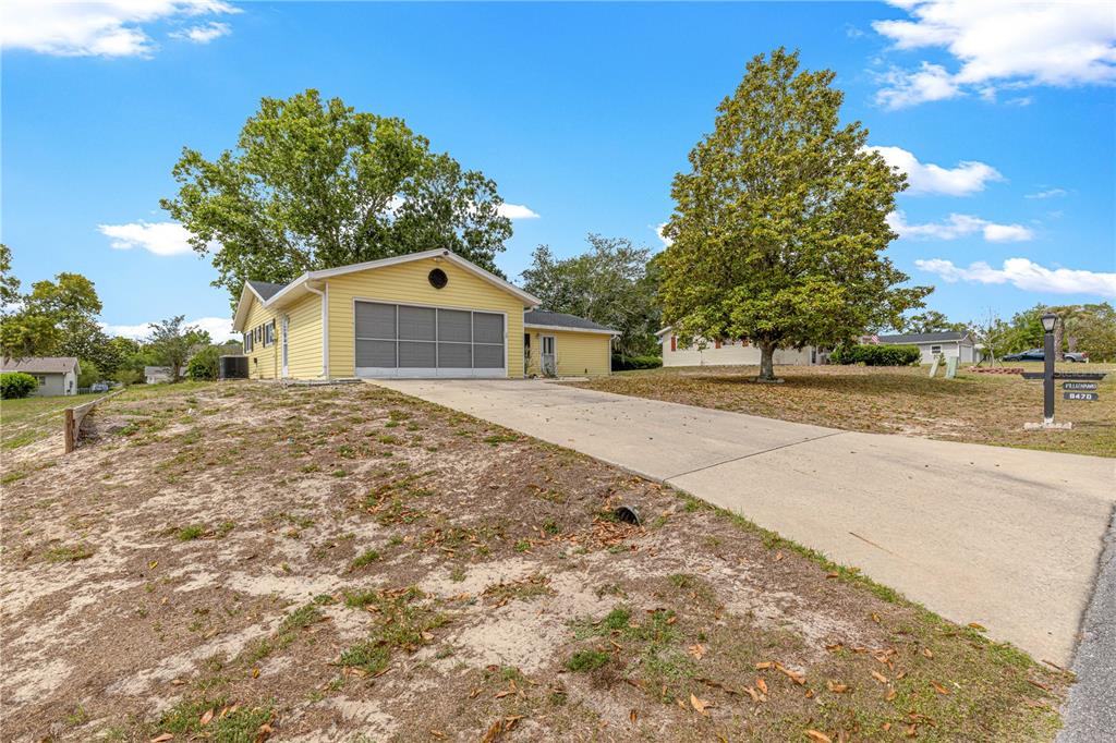 8470 Southwest 107th Place Ocala, FL 34481 - Photo 35 of 44 a front view of a house with a yard and garage