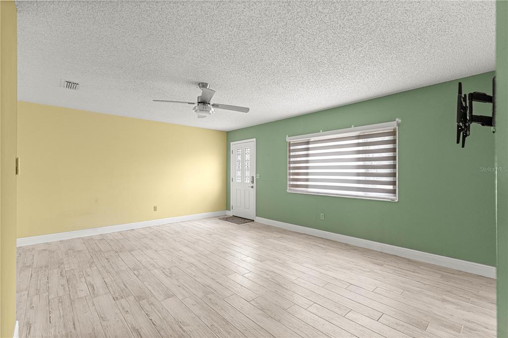 8470 Southwest 107th Place Ocala, FL 34481 - Photo 6 of 44 a view of an empty room with wooden floor and a window