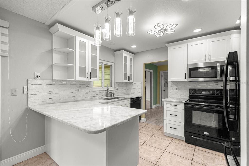 8470 Southwest 107th Place Ocala, FL 34481 - Photo 8 of 44 a kitchen with stainless steel appliances granite countertop a sink stove and refrigerator