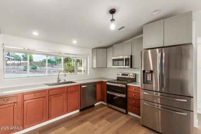 a kitchen with stainless steel appliances granite countertop a refrigerator and a stove top oven