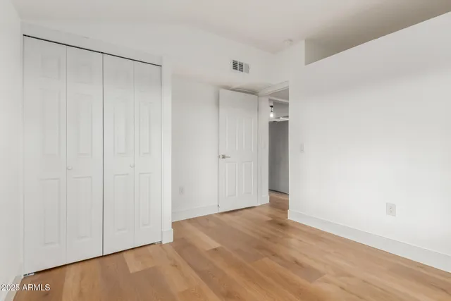 an empty room with wooden floor and sliding door