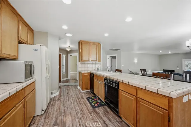 a kitchen with stainless steel appliances granite countertop a sink and wooden cabinets