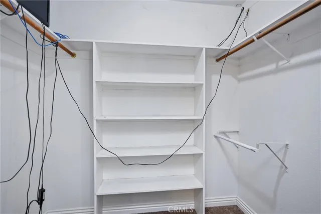 a view of walk in closet with empty racks