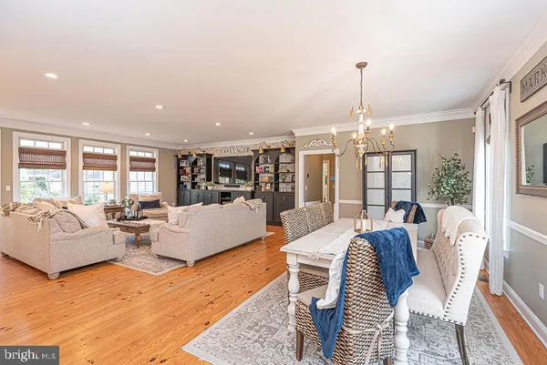 a dining room with furniture a chandelier and wooden floor