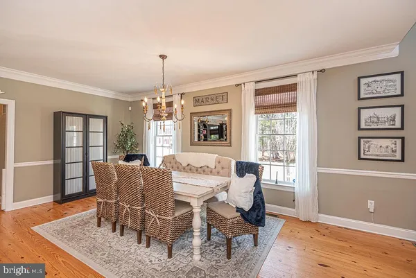 a kitchen with stainless steel appliances kitchen island granite countertop a dining table chairs and a refrigerator