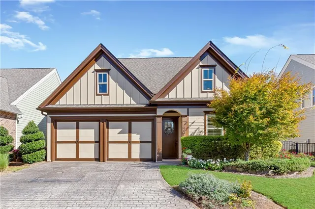 a front view of a house with a yard and potted plants