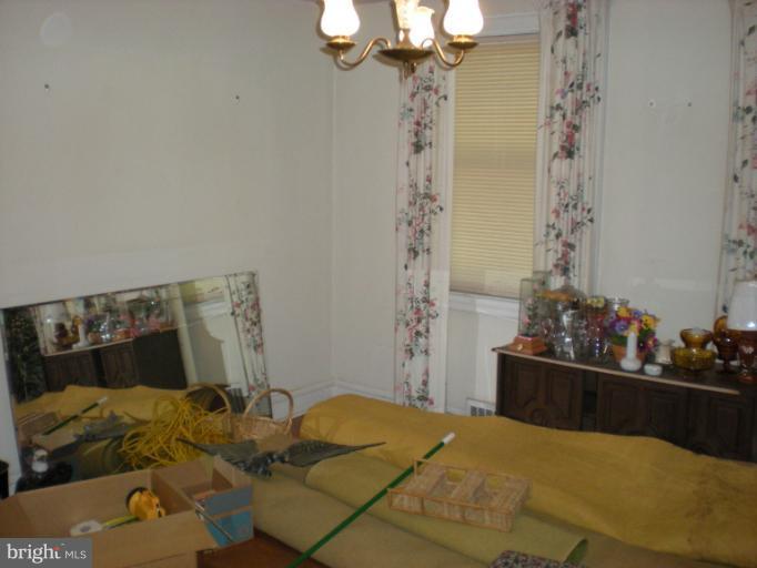 1233 Greystone Road Halethorpe, MD 21227 - Photo 18 of 30 a bed room with a bed and a chandelier
