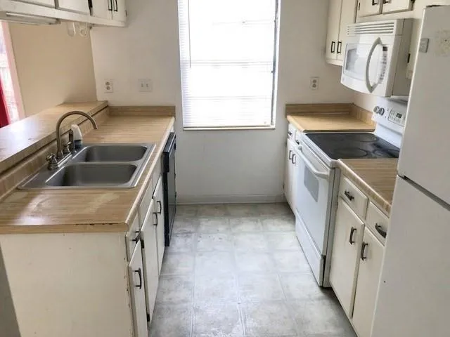 a kitchen with a sink stove and refrigerator