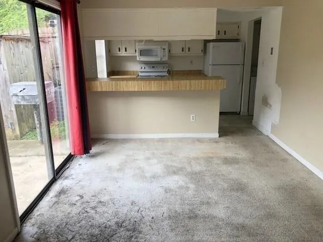 a view of a kitchen with a refrigerator and a window