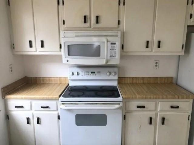 a kitchen with a stove and white cabinets
