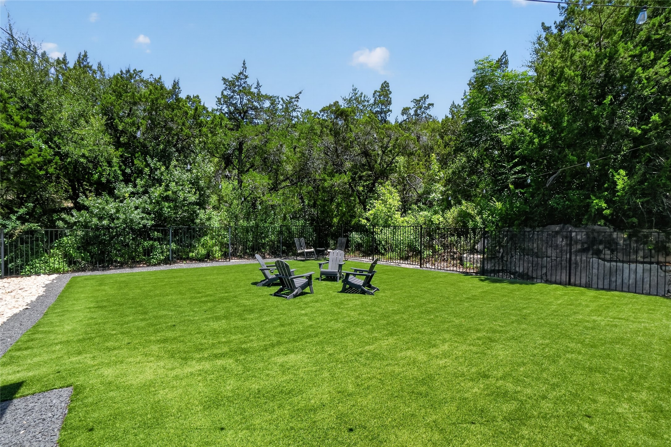 14916 Copper Ridge Lane Austin, TX 78734 - Photo 31 of 35 A fenced backyard offers a dedicated space for gathering with ample green turf and a lush tree line.
