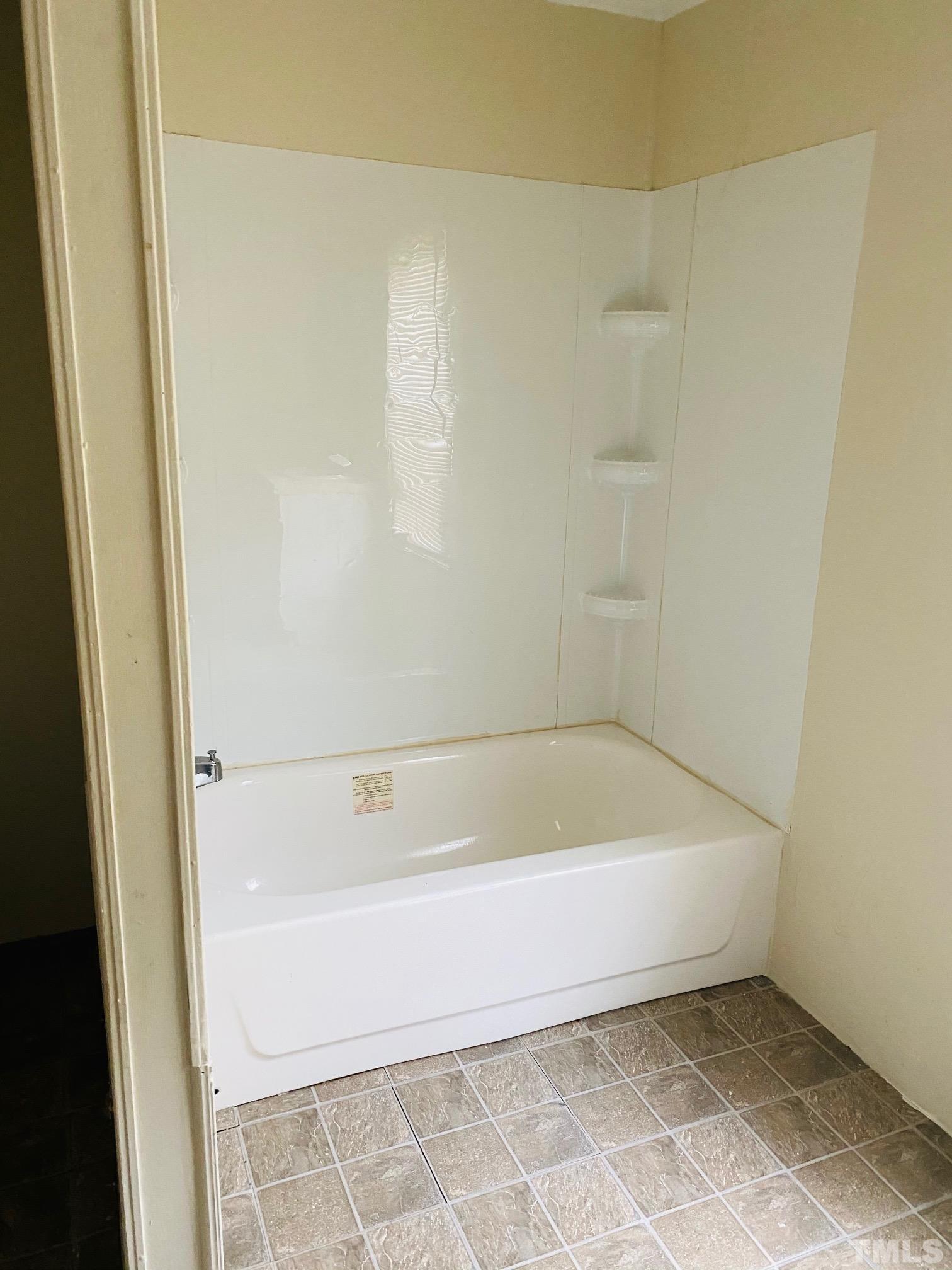 3288 Walters Road Creedmoor, NC 27522 - Photo 13 of 15 a bath tub sitting next to a white sink and vanity