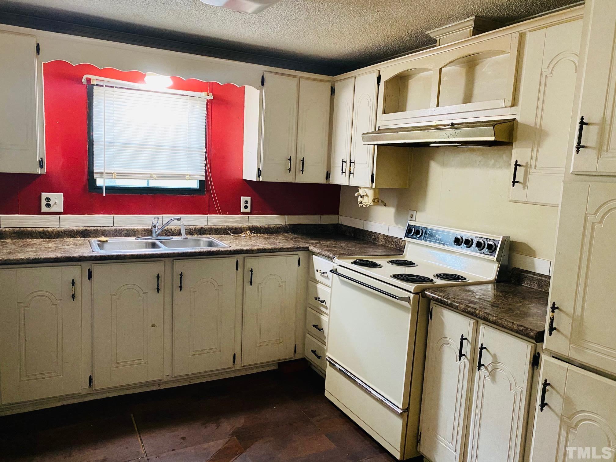 3288 Walters Road Creedmoor, NC 27522 - Photo 8 of 15 a kitchen with granite countertop a sink a stove and cabinets