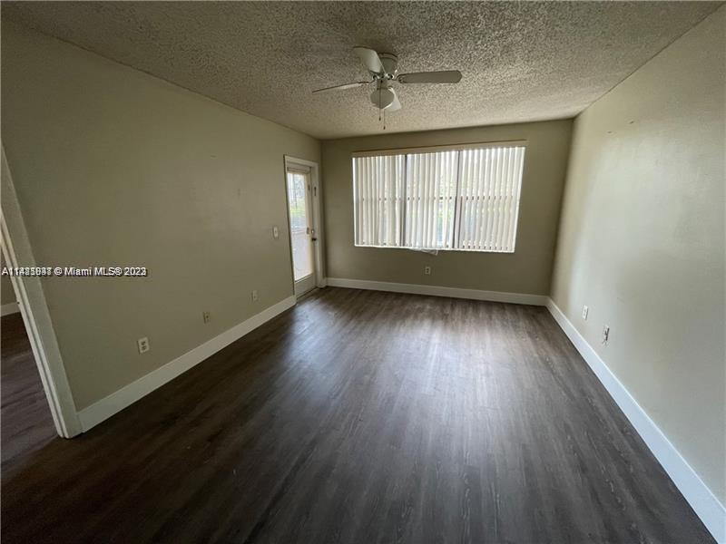 4481 West McNab Road, Unit 25 Pompano Beach, FL 33069 - Photo 2 of 5 an empty room with wooden floor and windows