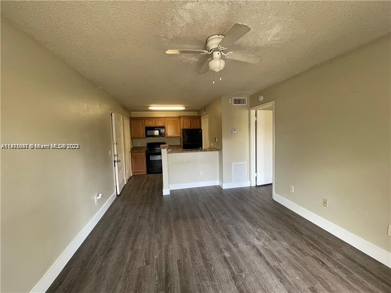 4481 West McNab Road, Unit 25 Pompano Beach, FL 33069 - Photo 5 of 5 a view of a livingroom with a kitchen counter tops and wooden floor