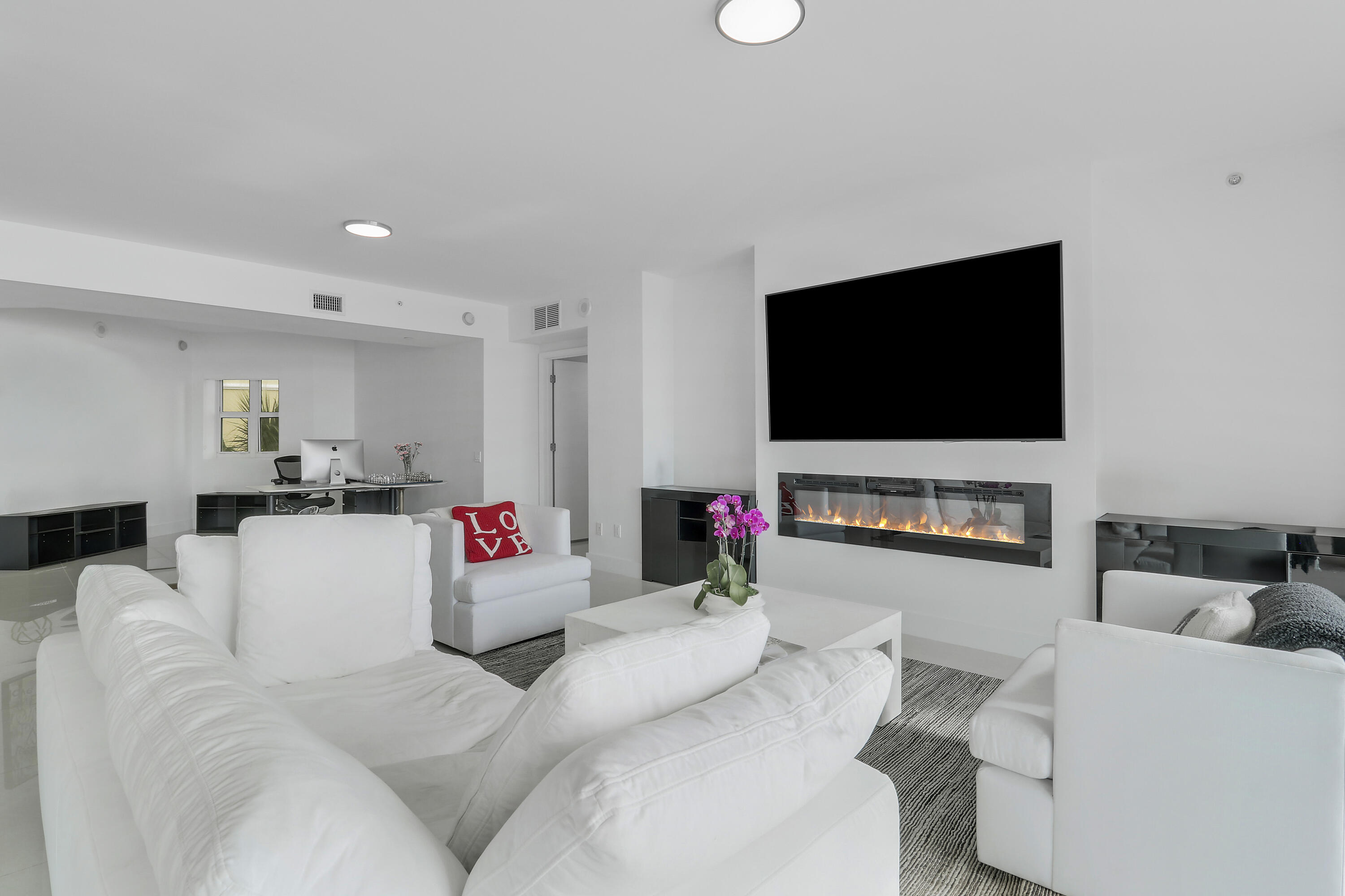 2640 Lake Shore Drive, Unit 307 Riviera Beach, FL 33404 - Photo 13 of 44 a living room with furniture and a flat screen tv