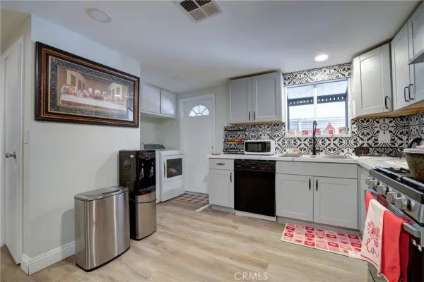a kitchen with granite countertop a stove top oven sink and cabinets