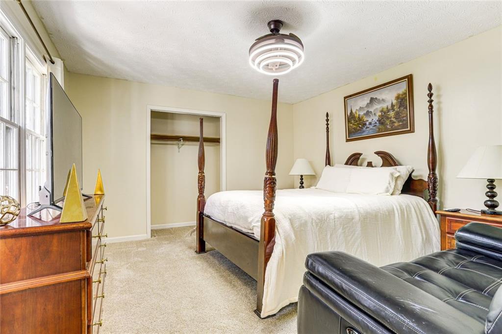 3595 Chastain Court Alpharetta, GA 30004 - Photo 10 of 13 a bedroom with a bed and a chandelier