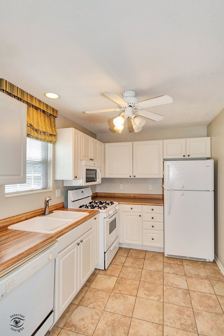 608 Huntington Court, Unit 608 Bourbonnais, IL 60914 - Photo 11 of 27 a kitchen with a sink cabinets and window