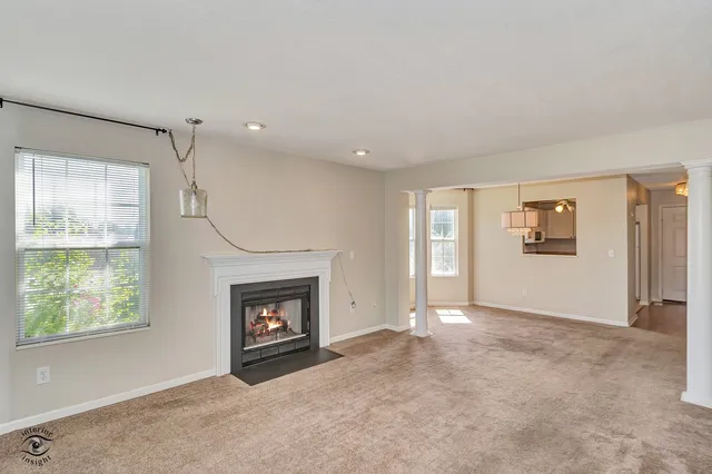 a view of an empty room with window and fireplace